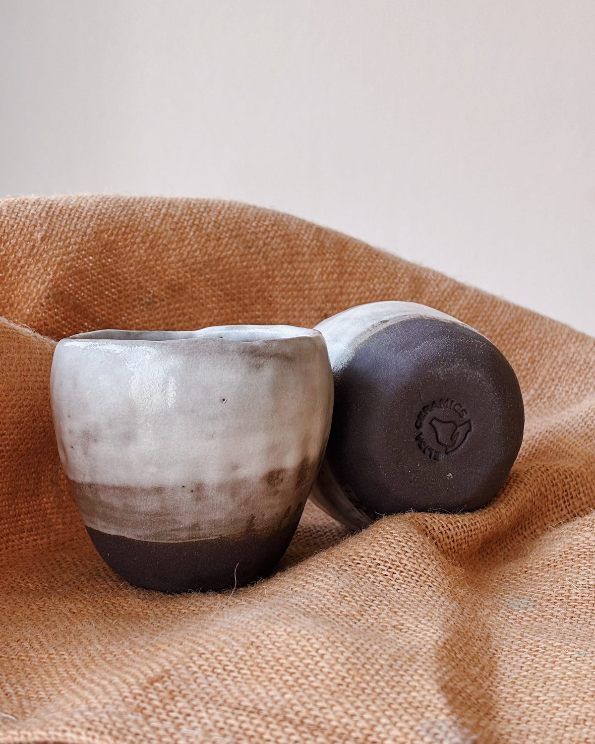 Two ceramic bowls on a textured fabric surface