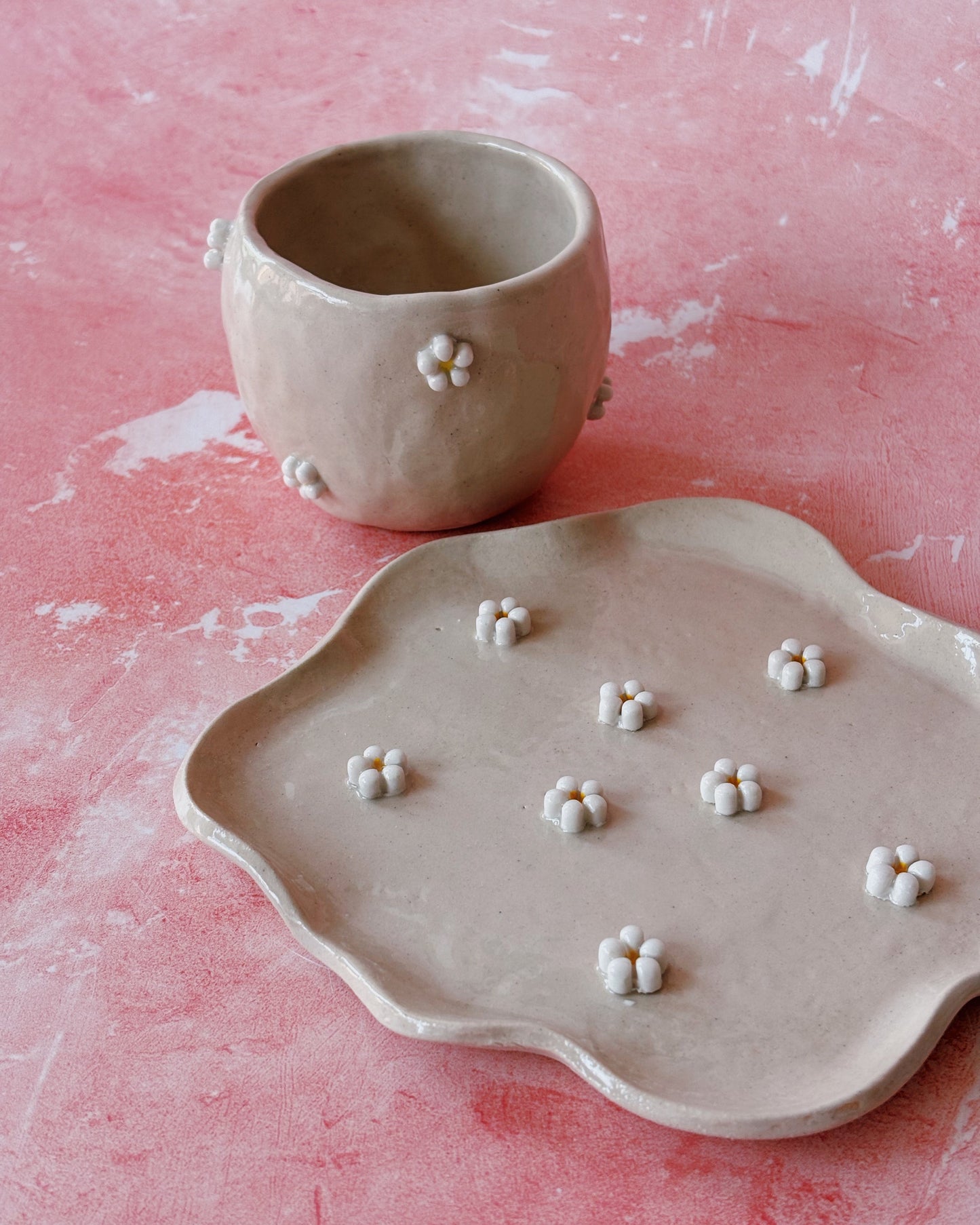 Handmade ceramic mug and plate with white handmade ceramic daisies applied to them