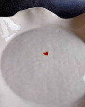 Carica l'immagine nel visualizzatore di Gallery, A ceramic bowl with a tiny heart in the middle on a black background