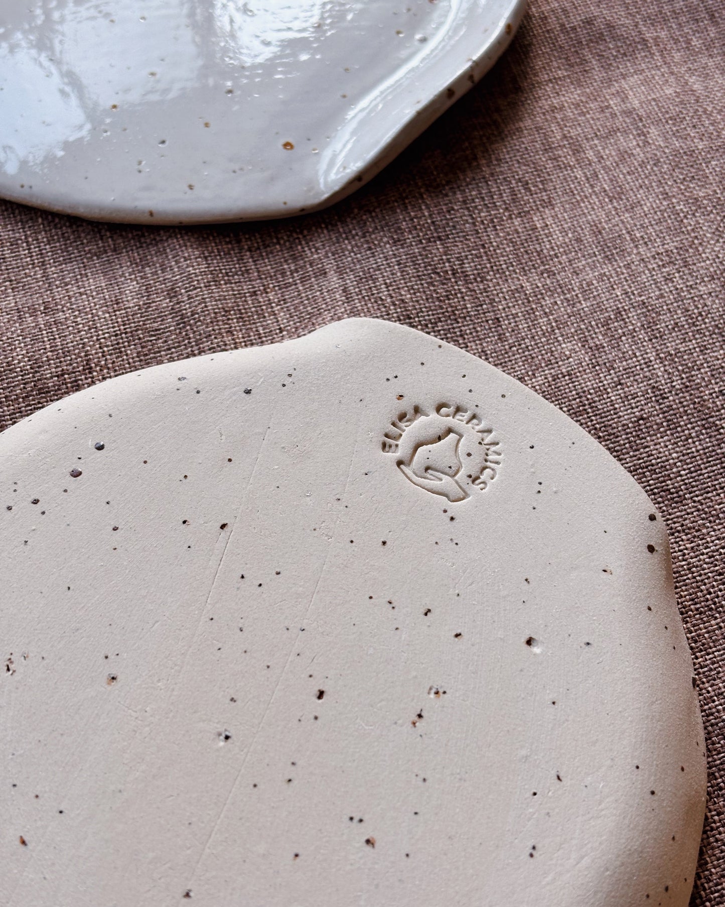 Close-up of a ceramic plate with an embossed design on a textured surface