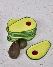 Load image into Gallery viewer, Avocado Spoon Rest set stacked on a countertop with whole avocados beside them.