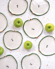 Carica l'immagine nel visualizzatore di Gallery, Handmade Apple Spoon Rest ceramic plates with green borders and green apples on a textured surface.