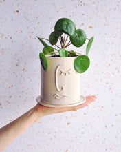 Load image into Gallery viewer, Resting Face Planter with a Pilea plant in a handmade stoneware pot, featuring a unique face design.
