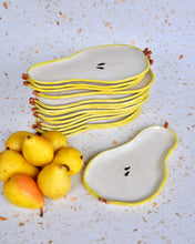Load image into Gallery viewer, Stack of handmade Pear Spoon Rests with yellow edges next to fresh pears, perfect for decorating your kitchen.