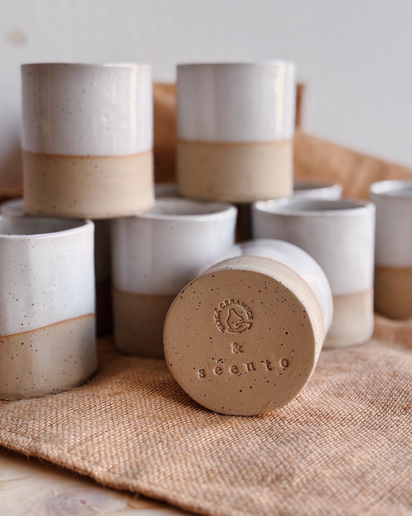 Set of ceramic cups with a brand logo on a textured surface