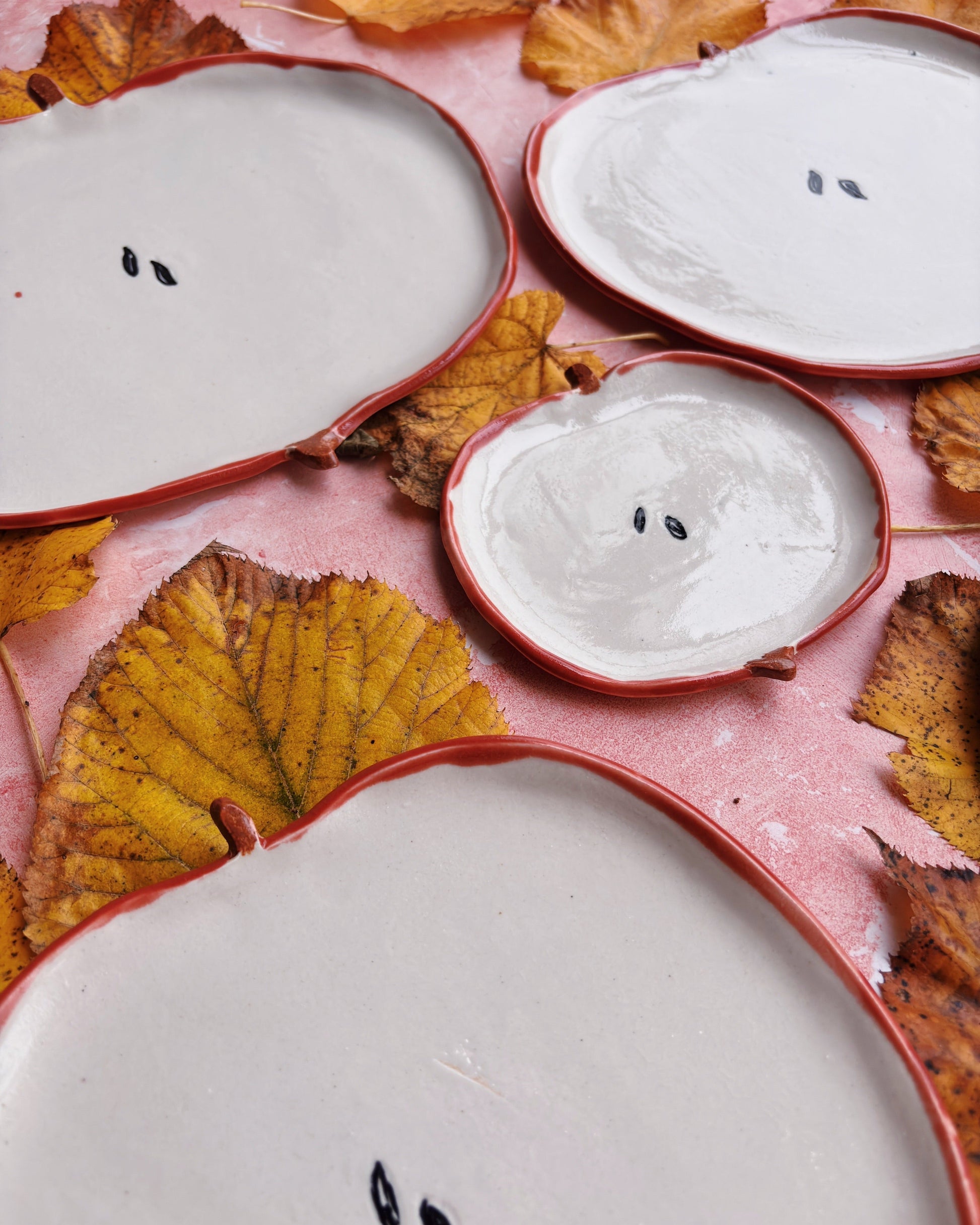 Apple Aperitivo Set handmade stoneware plates displayed with autumn leaves.