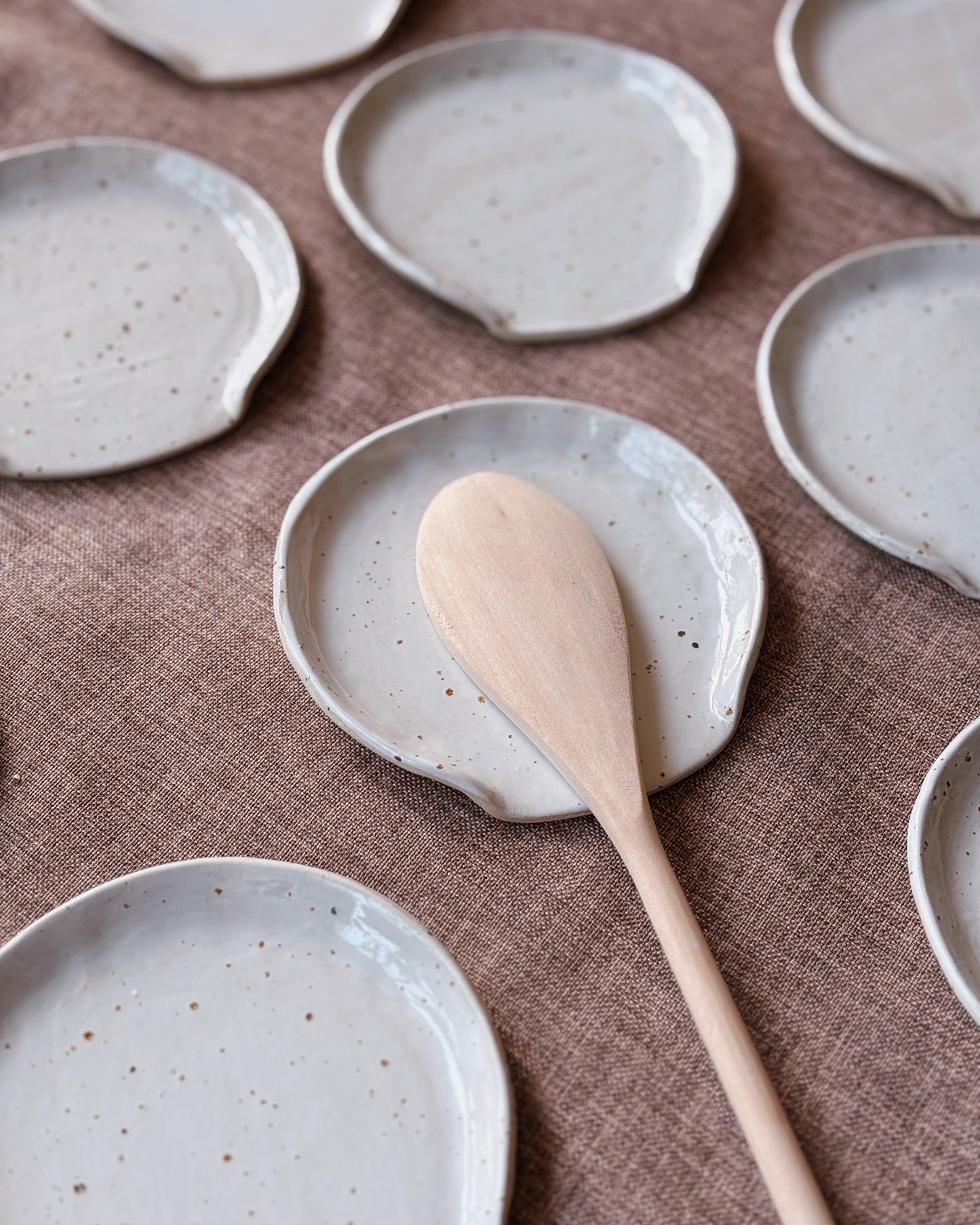Set of ceramic plates with a wooden spoon on a brown textured surface
