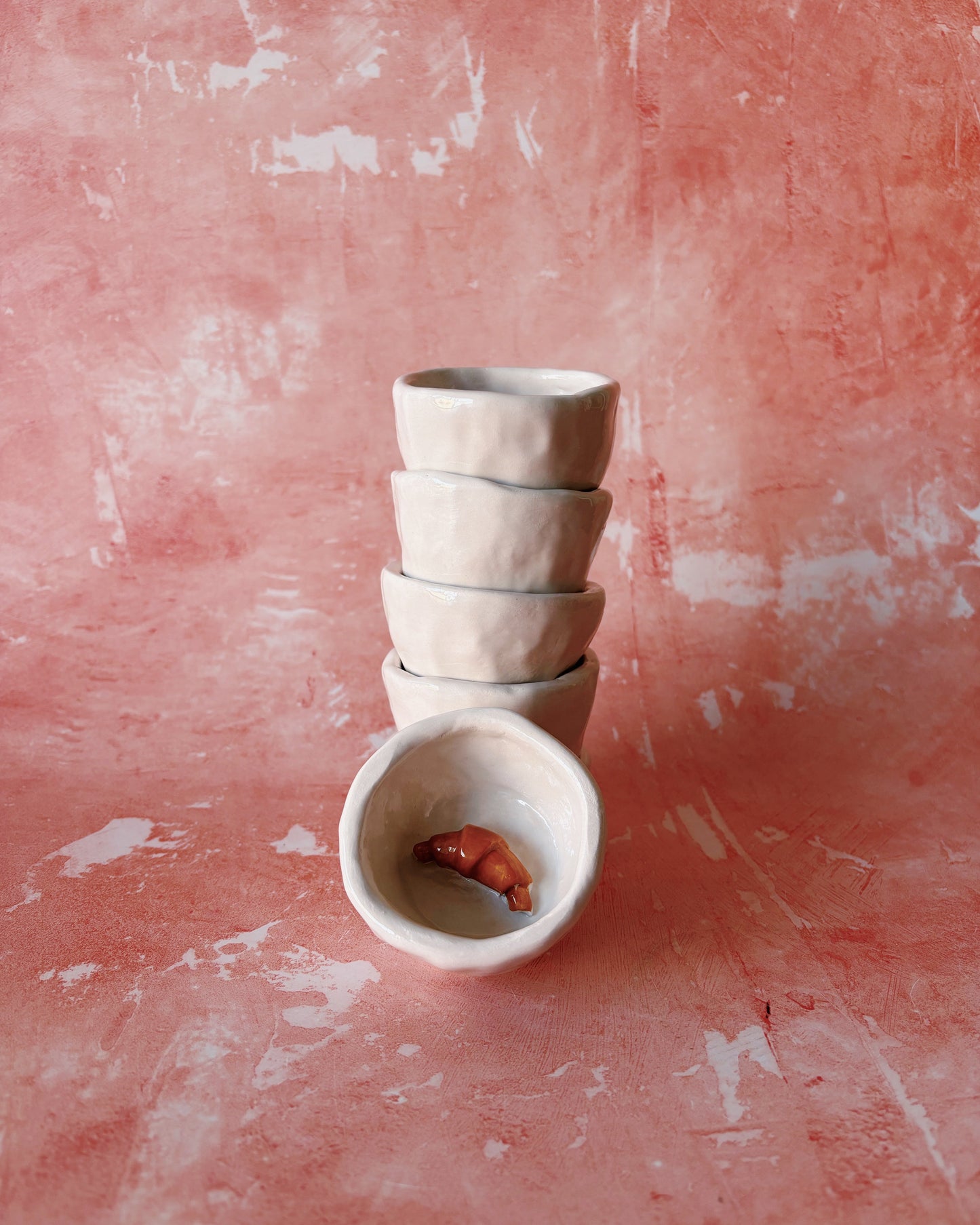 Croissant Espresso Mugs - Set of 6, handmade stoneware mugs stacked with one showing inside.