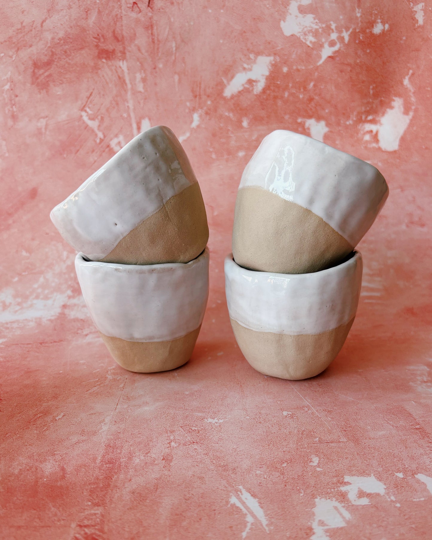 Set of ceramic bowls with two-tone design on a textured pink background