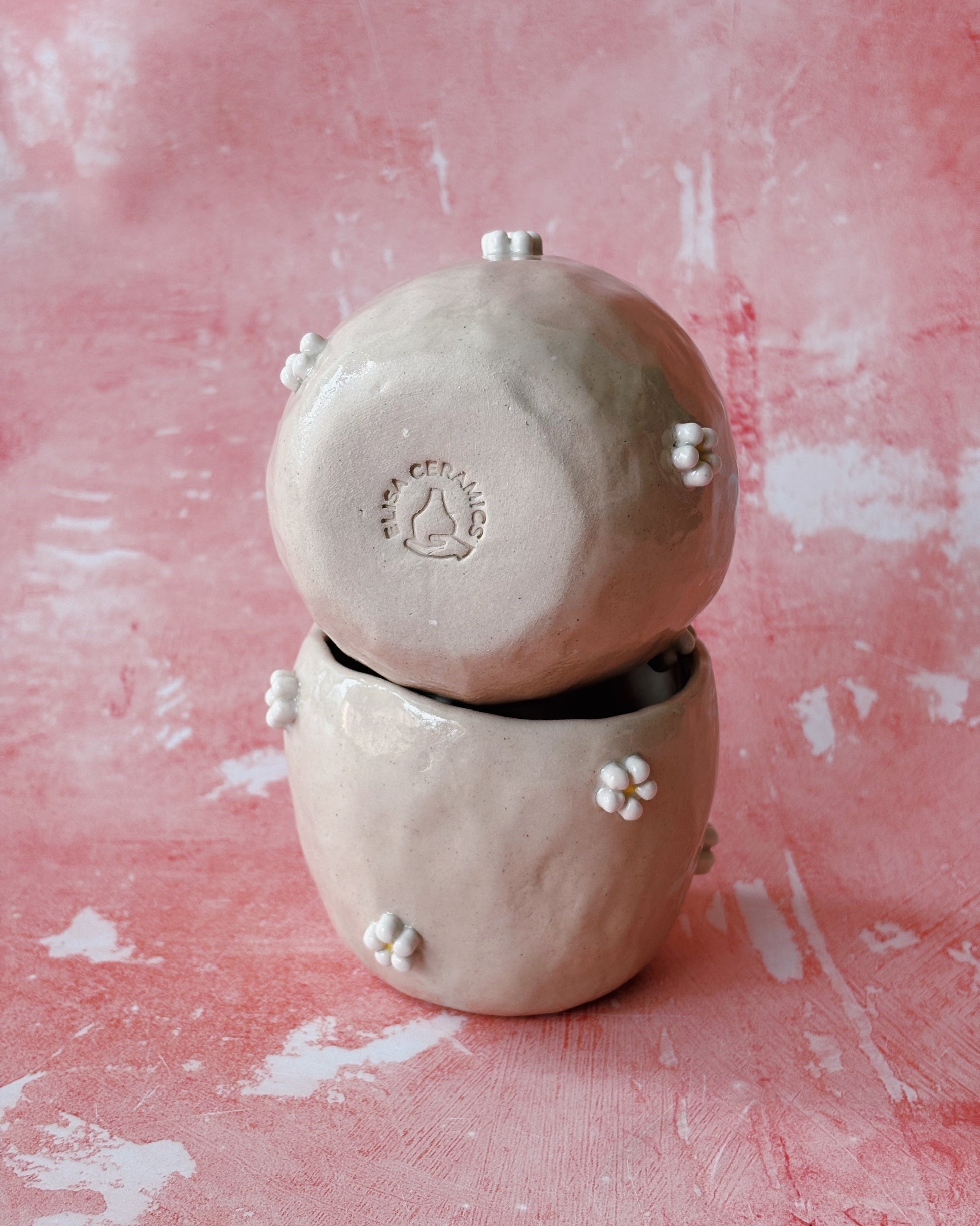 Two stacked ceramic bowls on a pink textured background