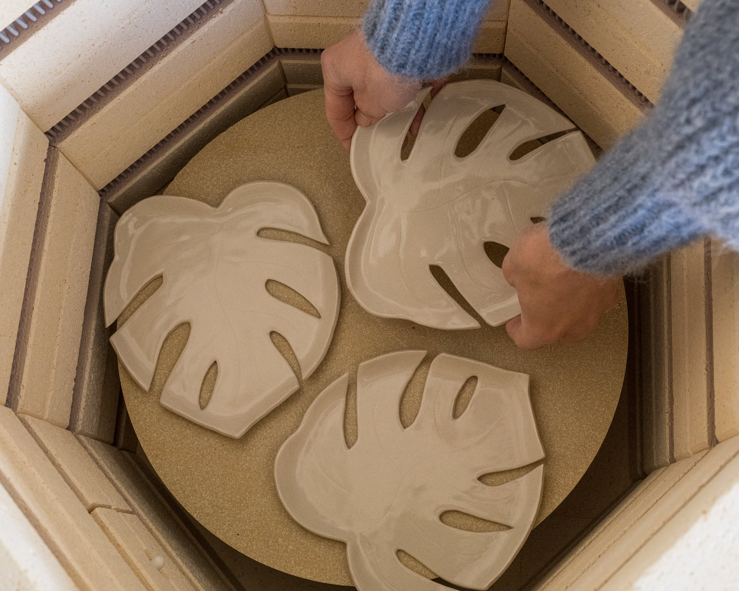 Person arranging leaf-shaped objects in a cardboard box