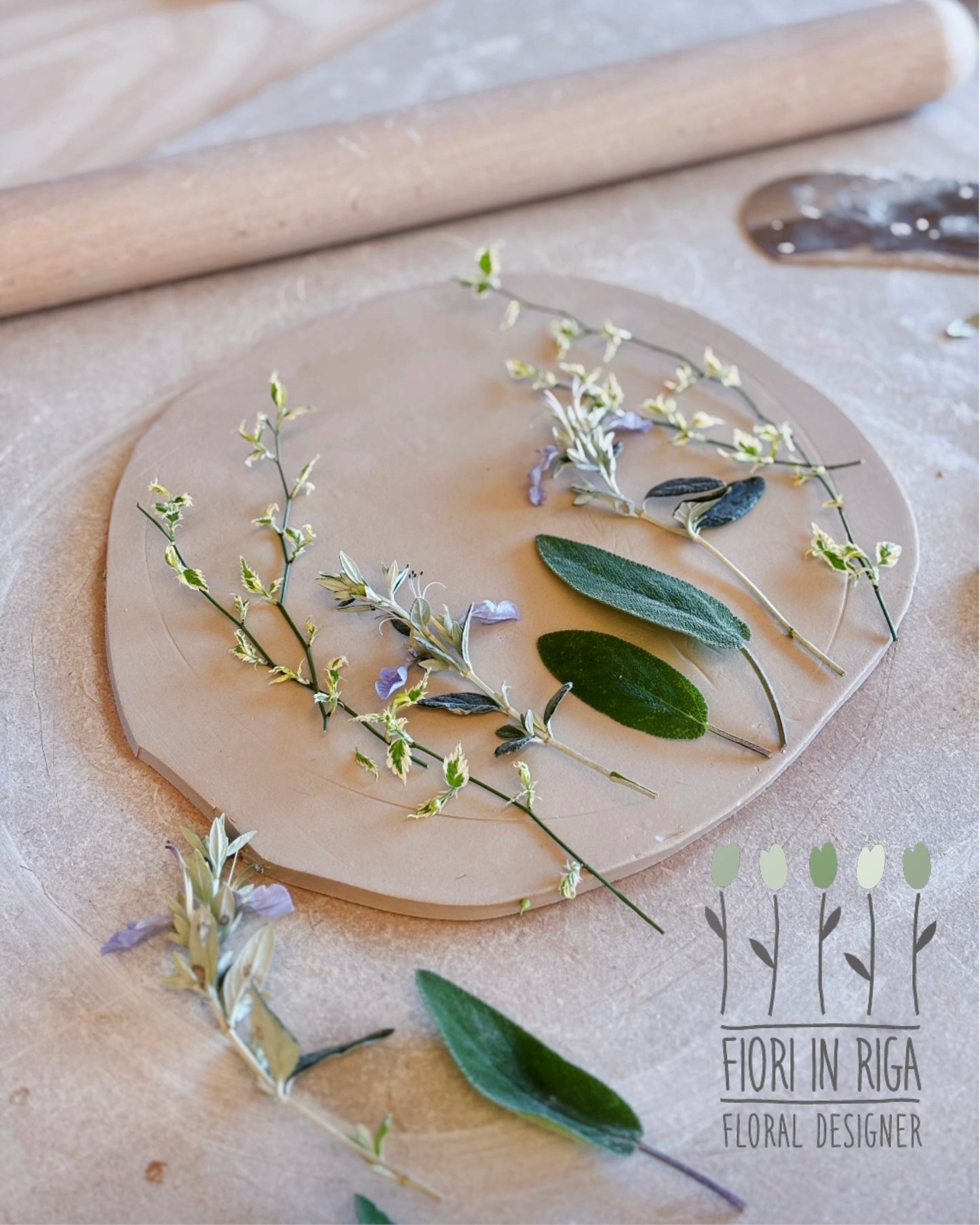 Wooden circular board with floral arrangement on a wooden surface, featuring the brand 'Fior in Riga'.
