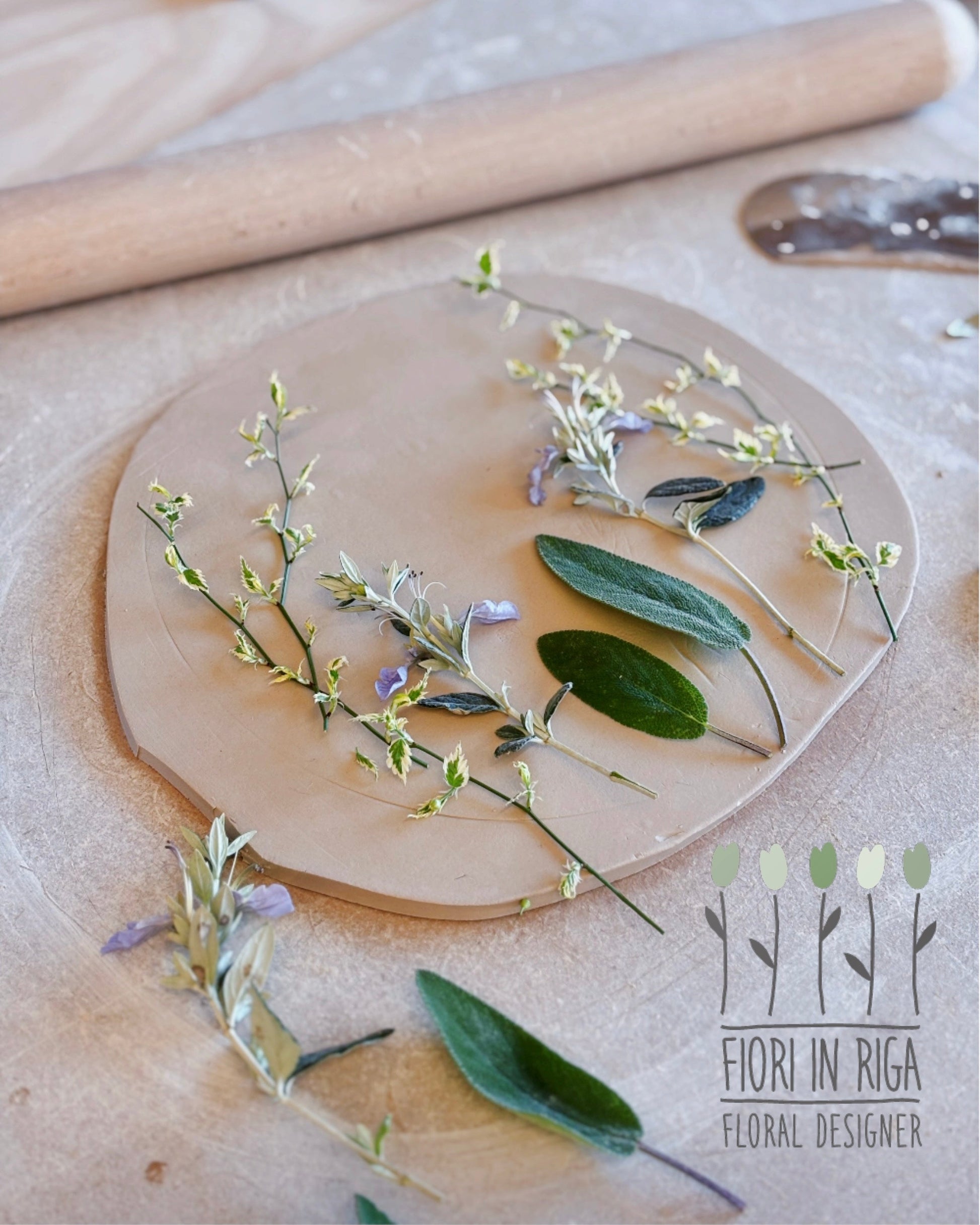 Wooden circular board with floral arrangement on a wooden surface, featuring the brand 'Fior in Riga'.