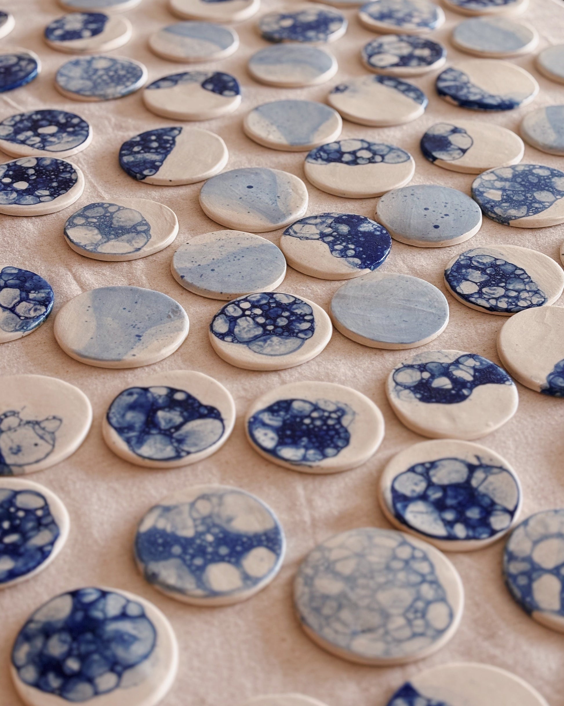 Collection of blue and white ceramic tiles with floral patterns on a light surface.