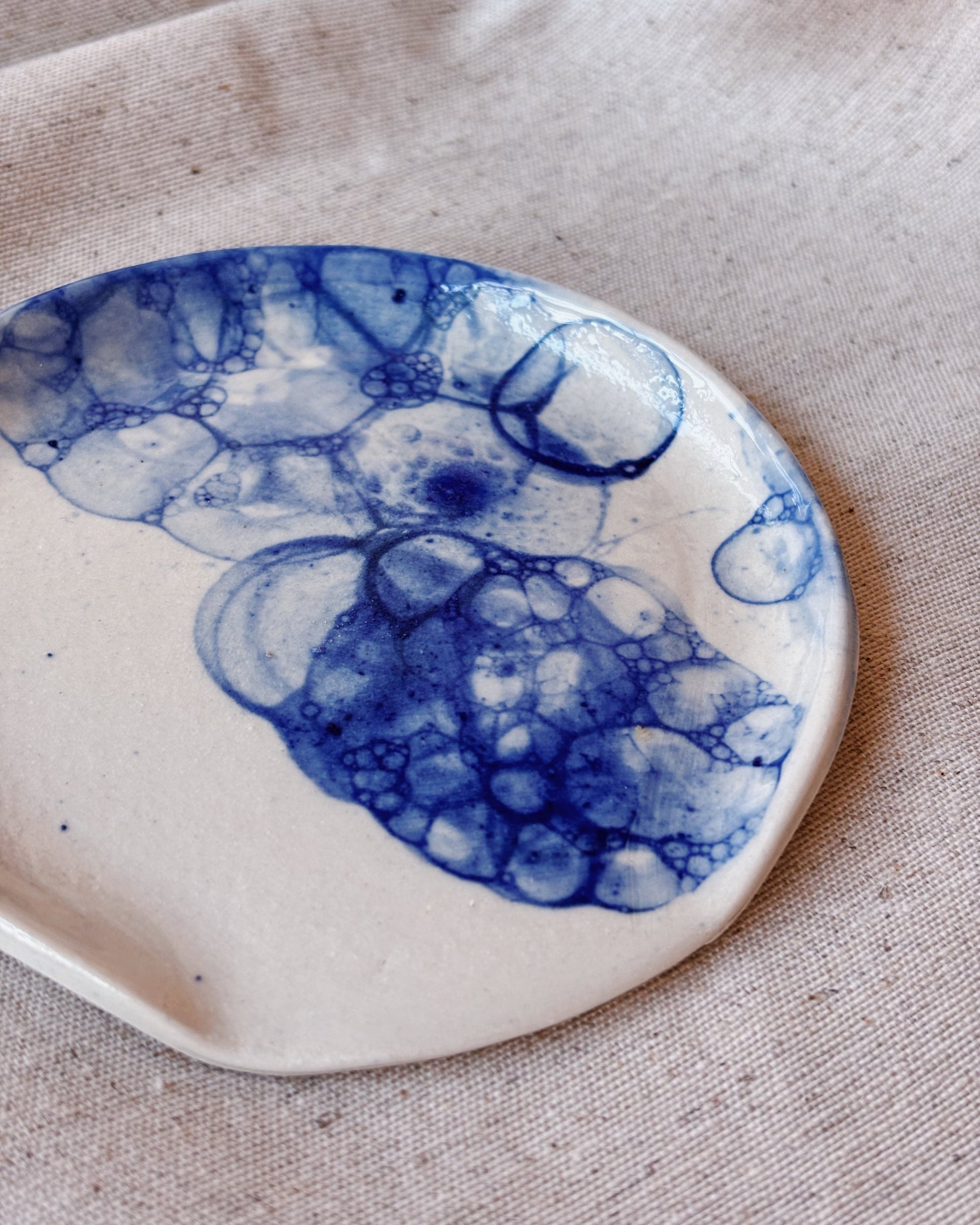 A ceramic white spoon rest with a marble blue effect