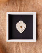 Load image into Gallery viewer, Decorative heart-shaped object in a white frame on a textured brown surface
