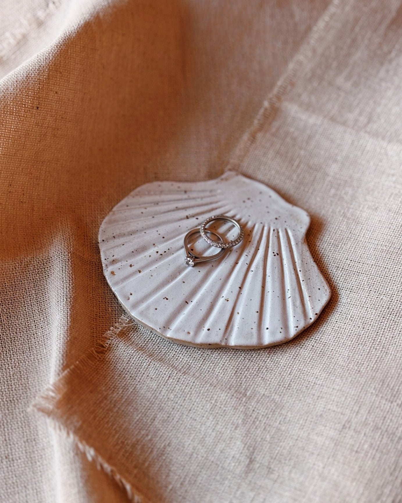 A shell ceramic trinket dish holding rings