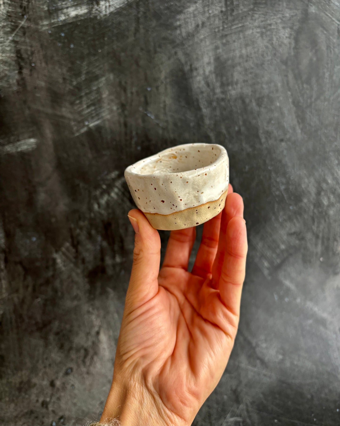 Set of 6 espresso cups, one on top of the other, with a speckled clay on a black background