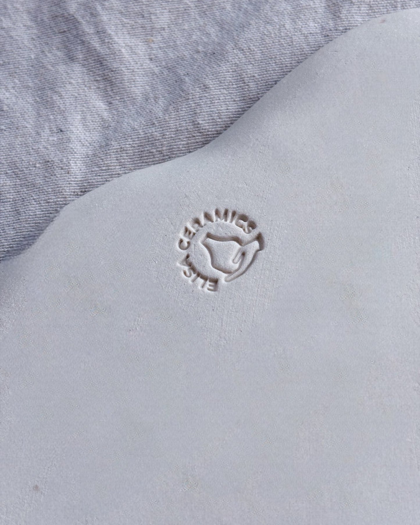 Close-up of a gray fabric surface with a brand logo embossed on it.