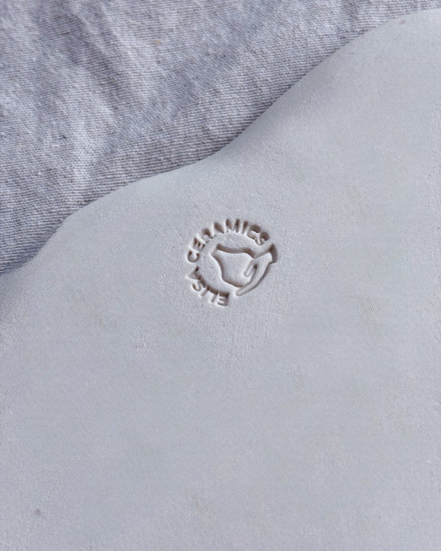 Close-up of a gray fabric surface with a brand logo embossed on it.