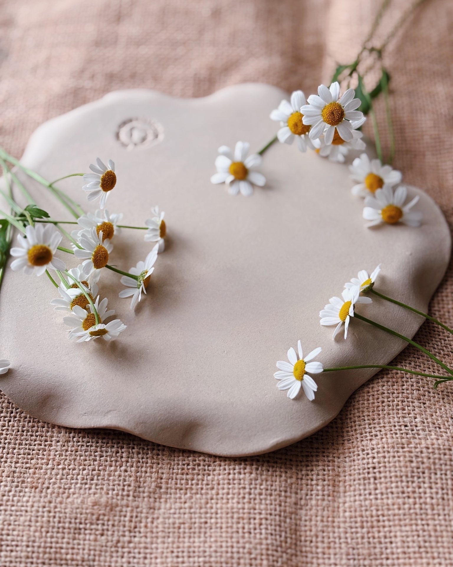 A ceramic jewellery plate made of stoneware with white ceramic handmade daisies