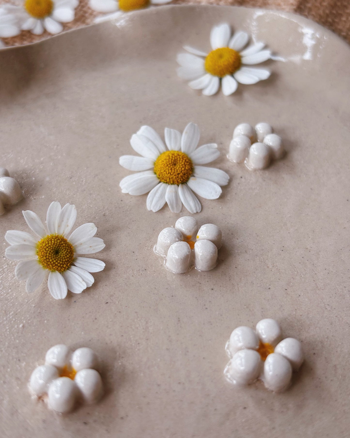 A ceramic jewellery plate made of stoneware with white ceramic handmade daisies