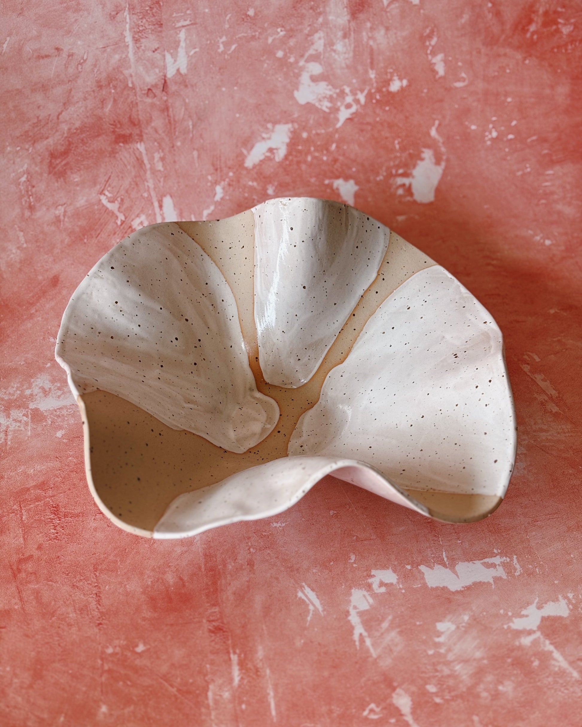 Ceramic bowl with a unique design on a textured pink surface