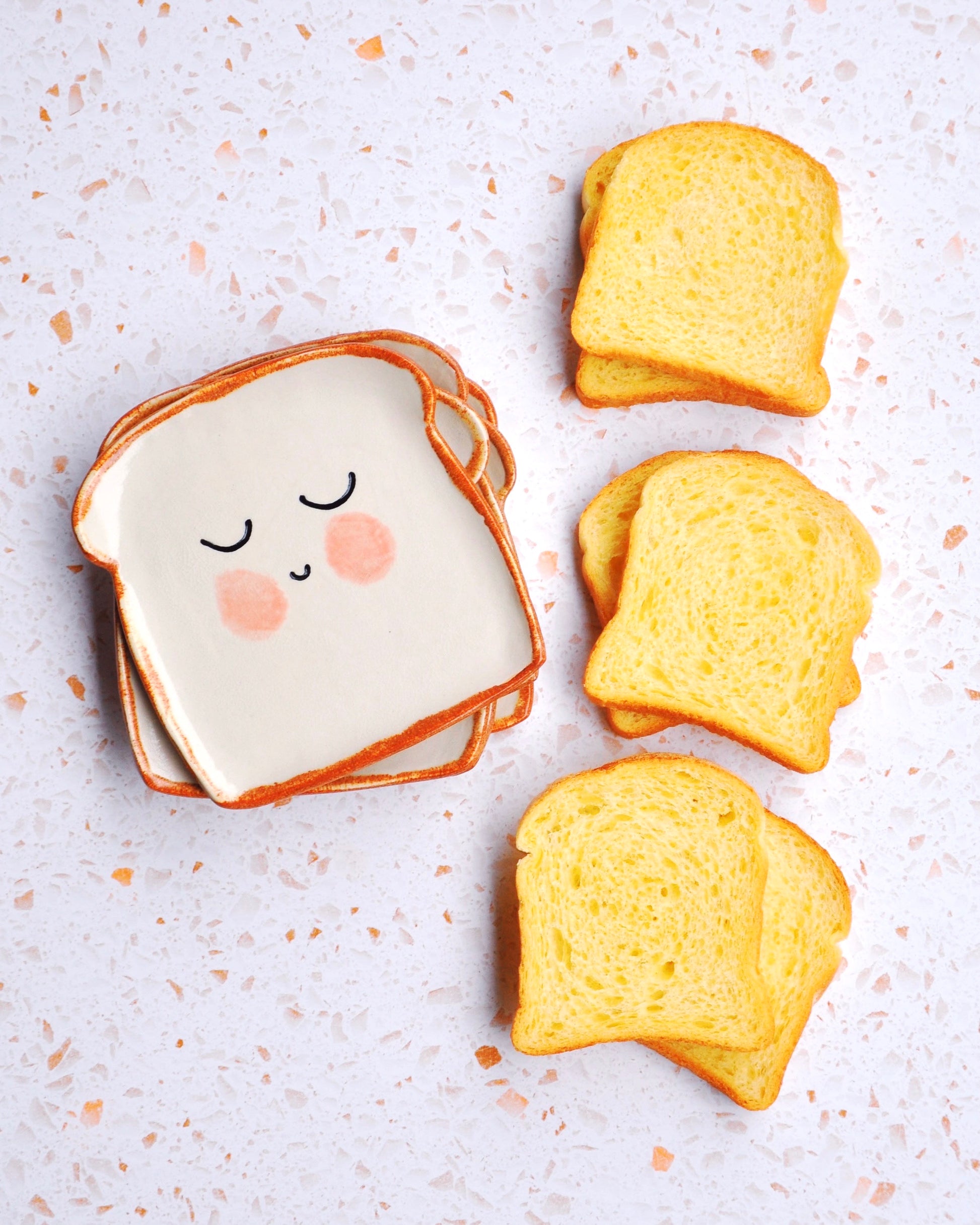 Mr Bready Spoon Rest next to slices of bread on a countertop, showcasing its handmade design for a fun kitchen touch.