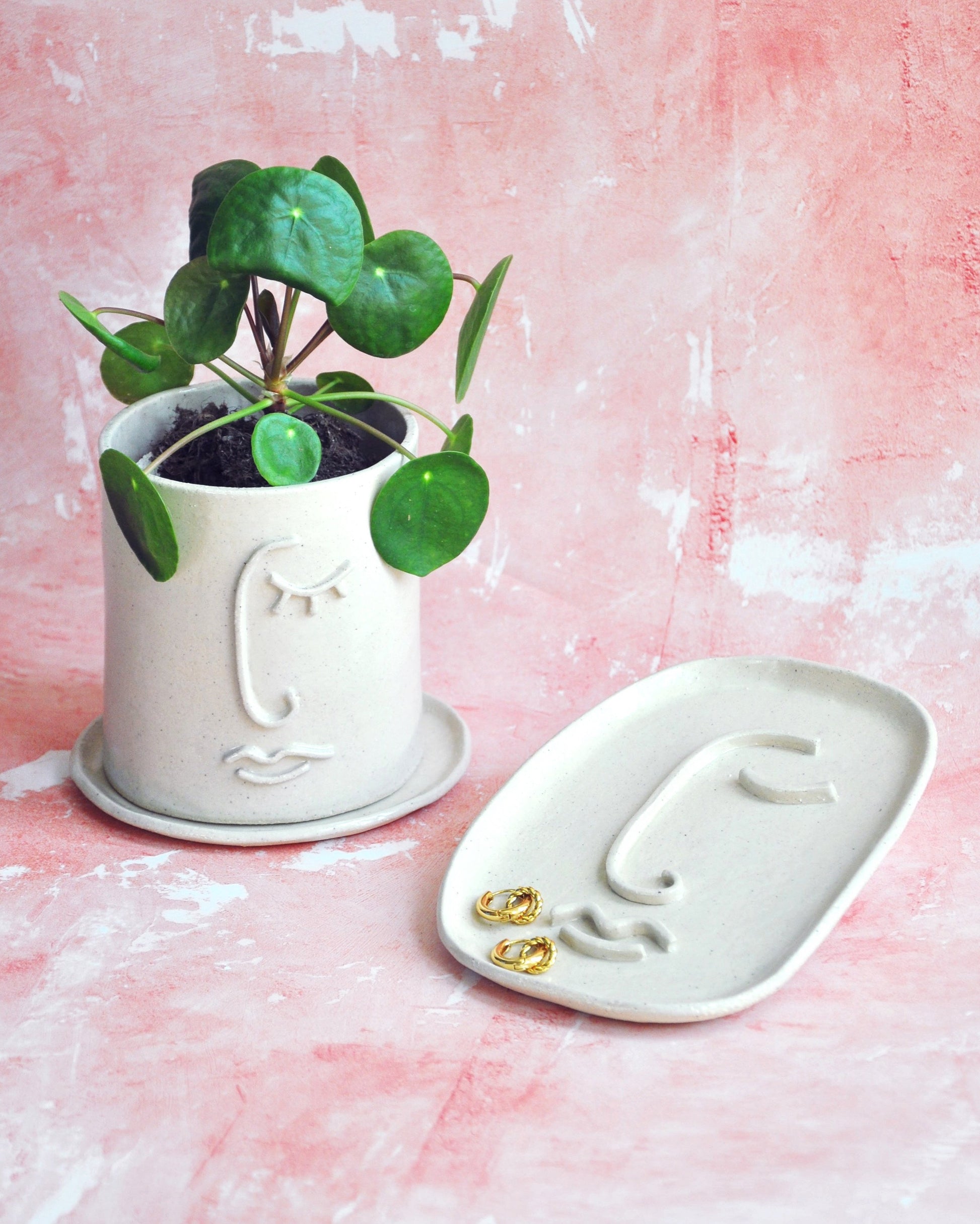 Resting Face Planter with succulent and matching saucer on a pink background, handmade stoneware for decor