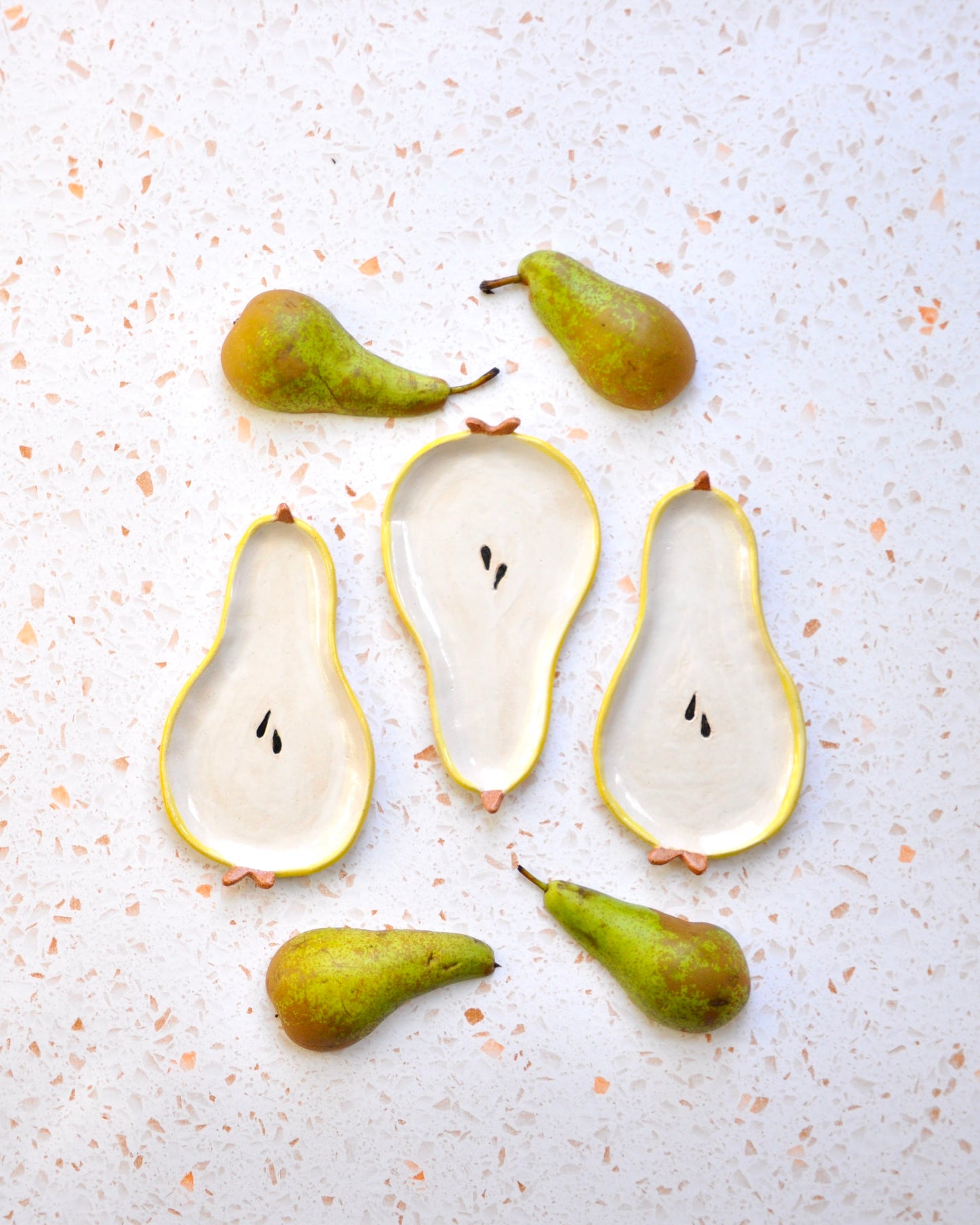 Handmade Pear Spoon Rest with decorative pears on a speckled countertop, ideal for kitchen use.