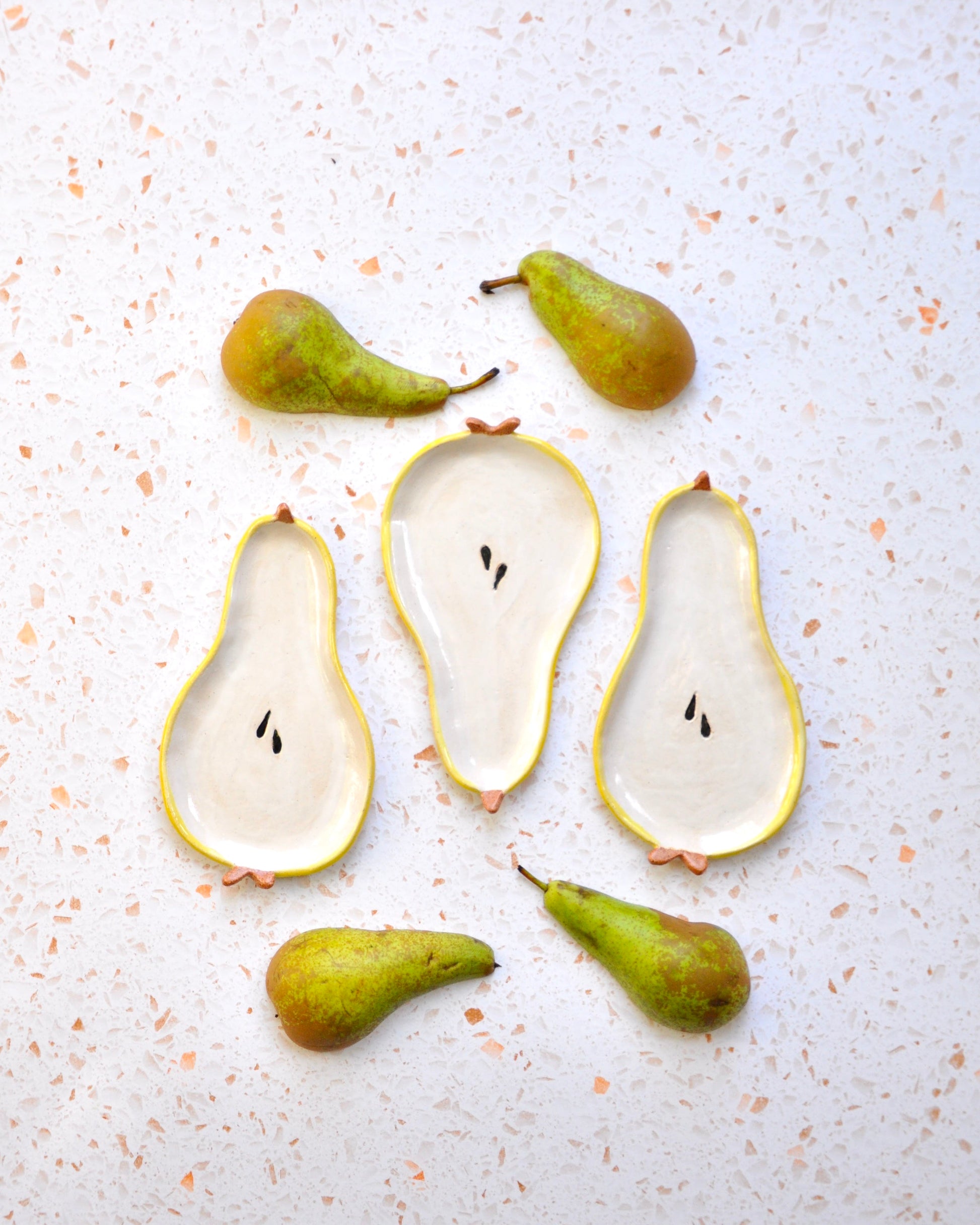 Handmade Pear Spoon Rest with decorative pears on a speckled countertop, ideal for kitchen use.