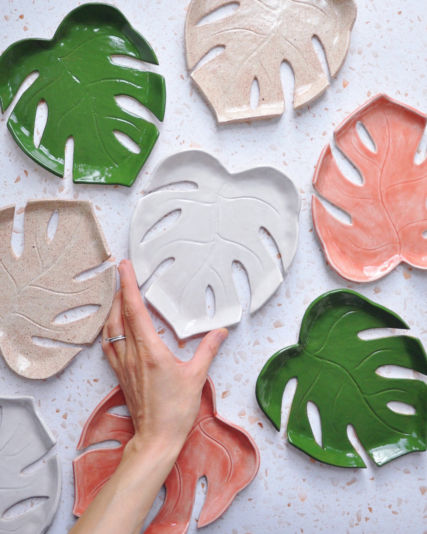 Monstera Leaf Plate collection showcasing handmade stoneware plates in various colors and designs.